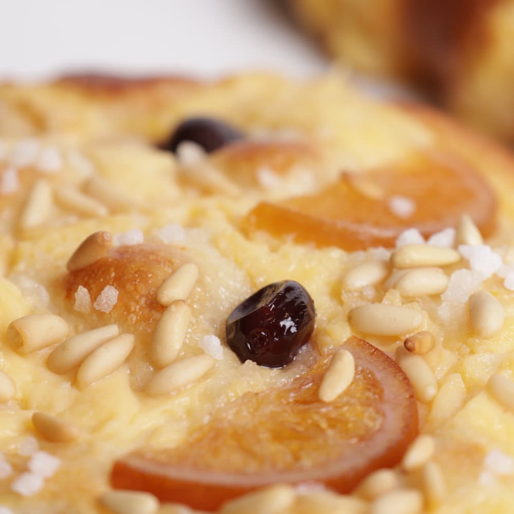 Detall de una coca de Sant Joan amb fruita confitada amb cirera amarena i crema
