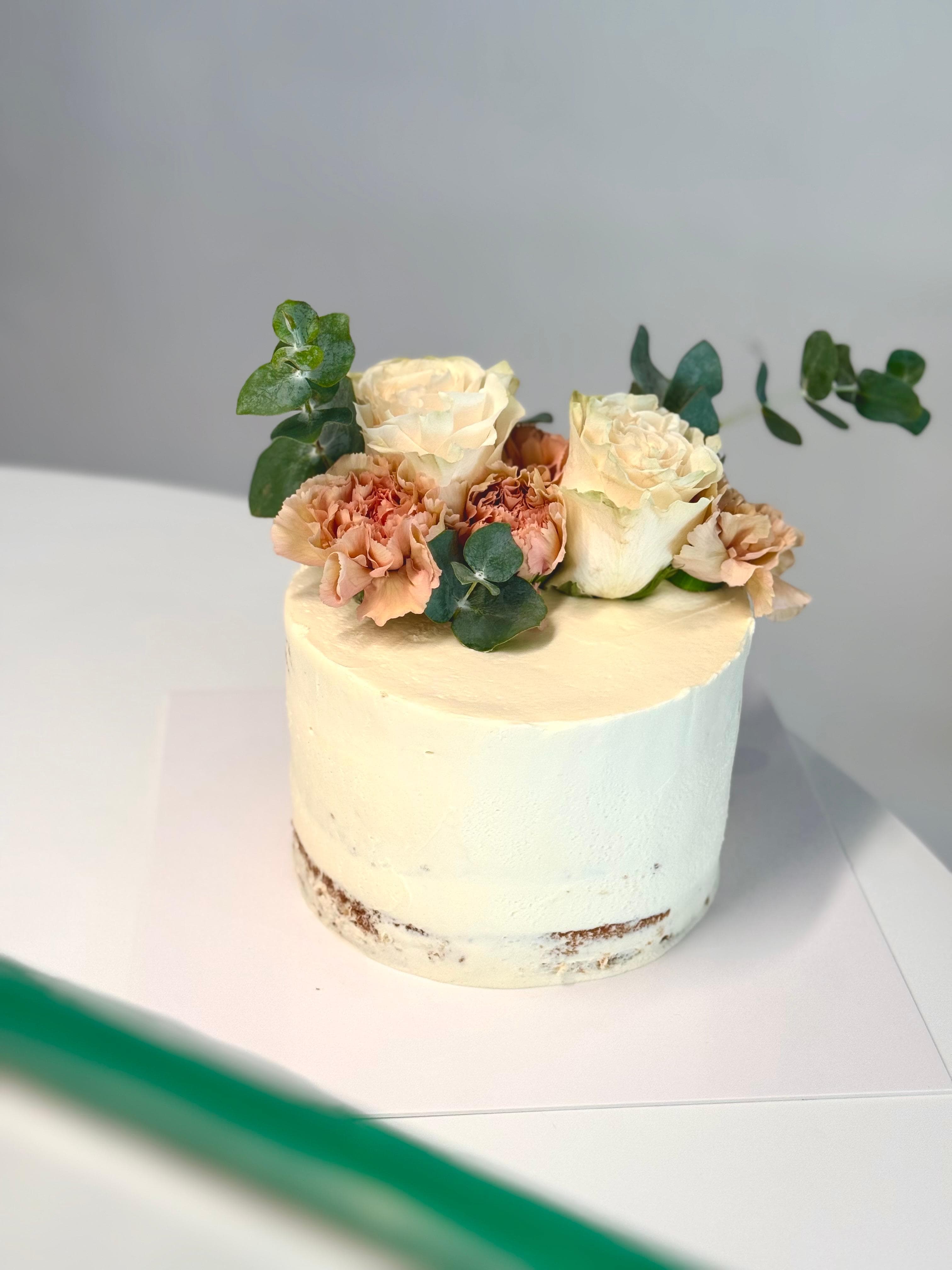 Imatge d'uns pastis de casament amb flors grogues i rosades